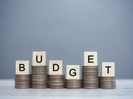 Wooden blocks with the word BUDGET on stack of coins. The concept about budget planning and allocation photo