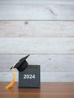 Study goals, 2024 Desk calendar with graduation hat. The concept for Resolution, Goal, Action, Planning, and manage time to success graduate. photo