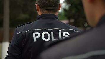 Close-up of a police officer standing in front of a man photo