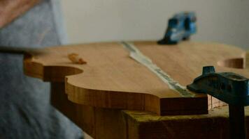 Luthier working with a chisel in workplace video