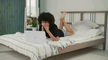 Online Learning, African American Student, Distance Lesson, Education at Home, Webinar Conference. Afro american woman using laptop while making online call feeling joy while lying on bed video