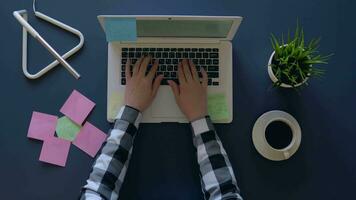 business woman typing on a laptop while sitting at the table and drinking coffee. Stickers with business ideas are on the table. overhead shot. 4k video