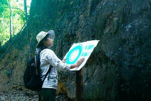 hembra geólogo utilizando mapa con iconos, examinando un natural camino y analizando rocas o grava. investigadores recoger muestras de biológico materiales ambiental y ecología investigación. foto