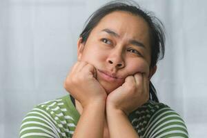 Bored woman sitting at desk at home. Asian woman who is bored, tired and needs a relax day. photo