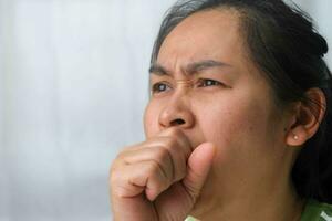 Illness young woman coughing at home. Sick woman coughing on her hands. photo