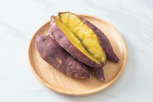Grilled or baked Japanese sweet potatoes on wood plate photo