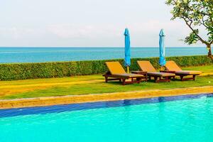 chair pool  or bed pool and umbrella around swimming pool with sea background photo