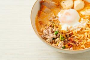 instant noodles with pork and meatballs in spicy soup photo