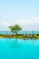 chair pool and umbrella around swimming pool photo