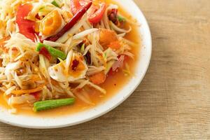 Som Tum - Thai Spicy green papaya salad with salty eggs photo