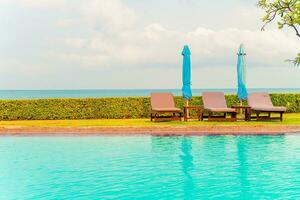 chair pool and umbrella around swimming pool photo