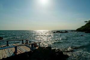 empty balcony and wooden bench with coast and sea background at Chedi Klang Nam in Chanthaburi, Thailand photo