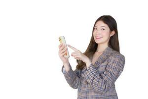 Asian professional female with black long hair wearing plaid suit while she acts enjoy with success of work and looking at camera using smartphone while isolated white background. photo