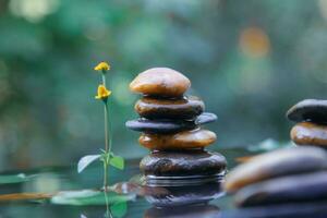 Stack of Balanced rocks pyramid on water with Golden light natural peace concepts bokeh on background photo
