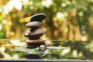 Relaxation and peace mood Balanced rocks pyramid on water with Golden light natural peace concepts bokeh on background photo