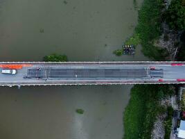 reparar de un hormigón puente a través de un río en el campo. reparar de un la carretera sección. aéreo ver de renovación de el puente. peligroso paso foto