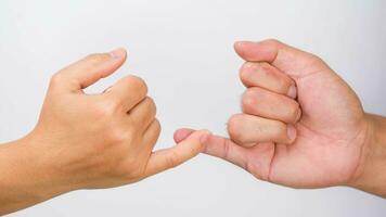 Man and woman making promise as a friendship concept or pinky swear hands sign isolated on white background. photo