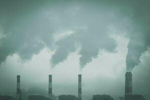 Cropped shot of coal power plant with steam pouring out of the stack. Industrial smoke stack of coal power plant in the morning. photo