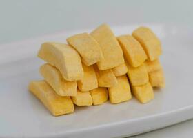 Healthy freeze dried fruits. Freeze-dried mango in plate on table, close-up. photo