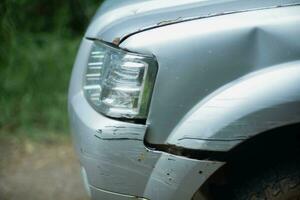 The car bumper was cracked and had deep scratches to the paint. Scratches on the front bumper of a car due to a minor accident. photo