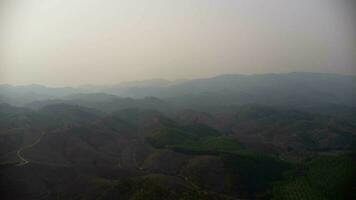 Mountain destroyed by human for cultivate plants. Aerial view of mountains covered in haze from burning forests. Areas with dense smog and covered with PM2.5. Air pollution and ecological problems photo