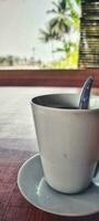 Portrait of a white coffee cup placed on a brown wooden table photo