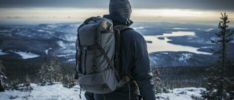 AI generated Back view of a climber standing atop a snowy peak, embodying the success and fulfillment of a challenging winter hike. photo