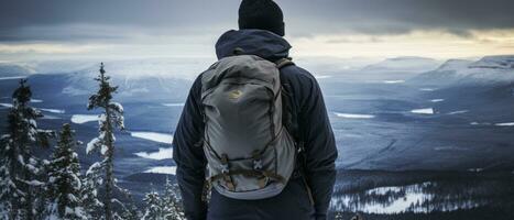 AI generated Back view of a climber standing atop a snowy peak, embodying the success and fulfillment of a challenging winter hike. photo