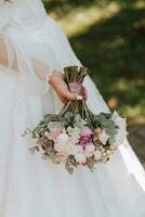 wedding bouquet in the hands of a young girl in a wedding dress photo