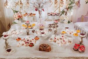 festivo postre mesa con dulces Boda caramelo bar, varios pasteles, chocolates en soportes foto