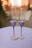 wedding glasses decorated in purple stand on the table in anticipation of the holiday photo