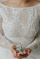 close-up cropped portrait of a bride holding a gypsophila flower photo