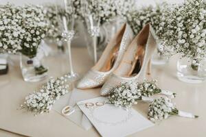 Boda anillos de el novia y novio con Boda ramos de flores de blanco flores dos hermosa oro Boda anillos de los hombres y De las mujeres anillos con adornos De las mujeres tacones altos zapatos. sitio para texto foto