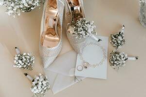 Boda anillos de el novia y novio con Boda ramos de flores de blanco flores dos hermosa oro Boda anillos de los hombres y De las mujeres anillos con adornos De las mujeres tacones altos zapatos. sitio para texto foto