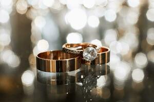 macro shot of wedding rings on a mirror surface with gorgeous bokeh in the background photo