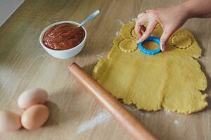 Cocinando hecho en casa galletas con manzana mermelada en un de madera cocina tablero foto