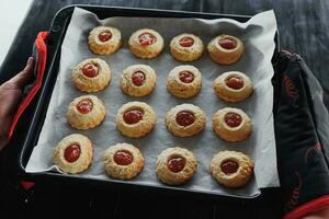 Image of a housewife with a tray of freshly baked muffins. Lifestyle, baking and spending time at home concept. photo