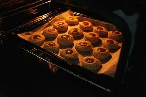 Image of homemade freshly baked cupcakes in a closed electric oven. Lifestyle, baking and spending time at home concept. photo