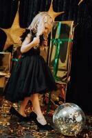 Merry Christmas and Happy Holidays. A cheerful girl poses in her mother's shoes against the background of Christmas presents. Children are having fun. Loving family with gifts in the room. photo