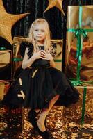 Merry Christmas and Happy Holidays. A cheerful girl poses in her mother's shoes against the background of Christmas presents. Children are having fun. Loving family with gifts in the room. photo