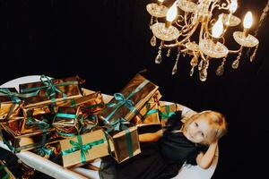 alegre Navidad y contento vacaciones. alegre pequeño niña en un bañera con Navidad regalos en oro envoltorios niños son teniendo divertida. amoroso familia con regalos en el habitación. foto