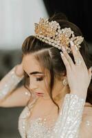 A young princess in an expensive luxurious dress with a gilded tiara on her head is standing. Stylish fashion photo