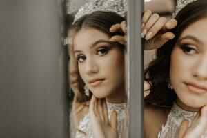 retrato de un niña en un Boda vestir cerca un espejo, con un corona en su cabeza. el concepto de un real banquete. horizontal foto. foto