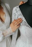 Details Wedding accessories. A brunette bride touches her dress with her hand. cropped photo. Beautiful hands. Open bust photo