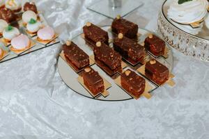 Festive dessert table with sweets. Wedding candy bar, various cakes, chocolates on stands. photo