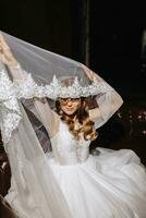 foto de el novia en un Boda vestir con mangas, levantamiento el velo arriba, oscuridad en el muchachas cara