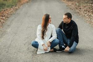 A man near his pregnant wife, resting in an autumn park. Support of the husband during pregnancy. The topic of mental health during pregnancy photo