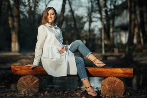 joven contento embarazada mujer relajante y disfrutando vida en naturaleza. el belleza de un mujer durante el embarazo. otoño estado animico durante el embarazo. yo mejora. foto