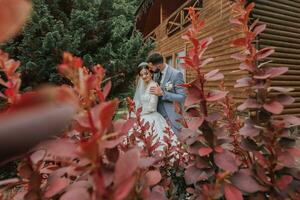 europeo Boda Pareja en el parque cerca el escaleras. el novia en un hermosa vestir con un largo tren y mangas novio en un clásico traje foto