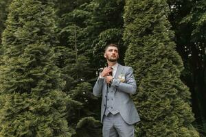 portrait of a groom of Caucasian appearance in a classic suit from below photo